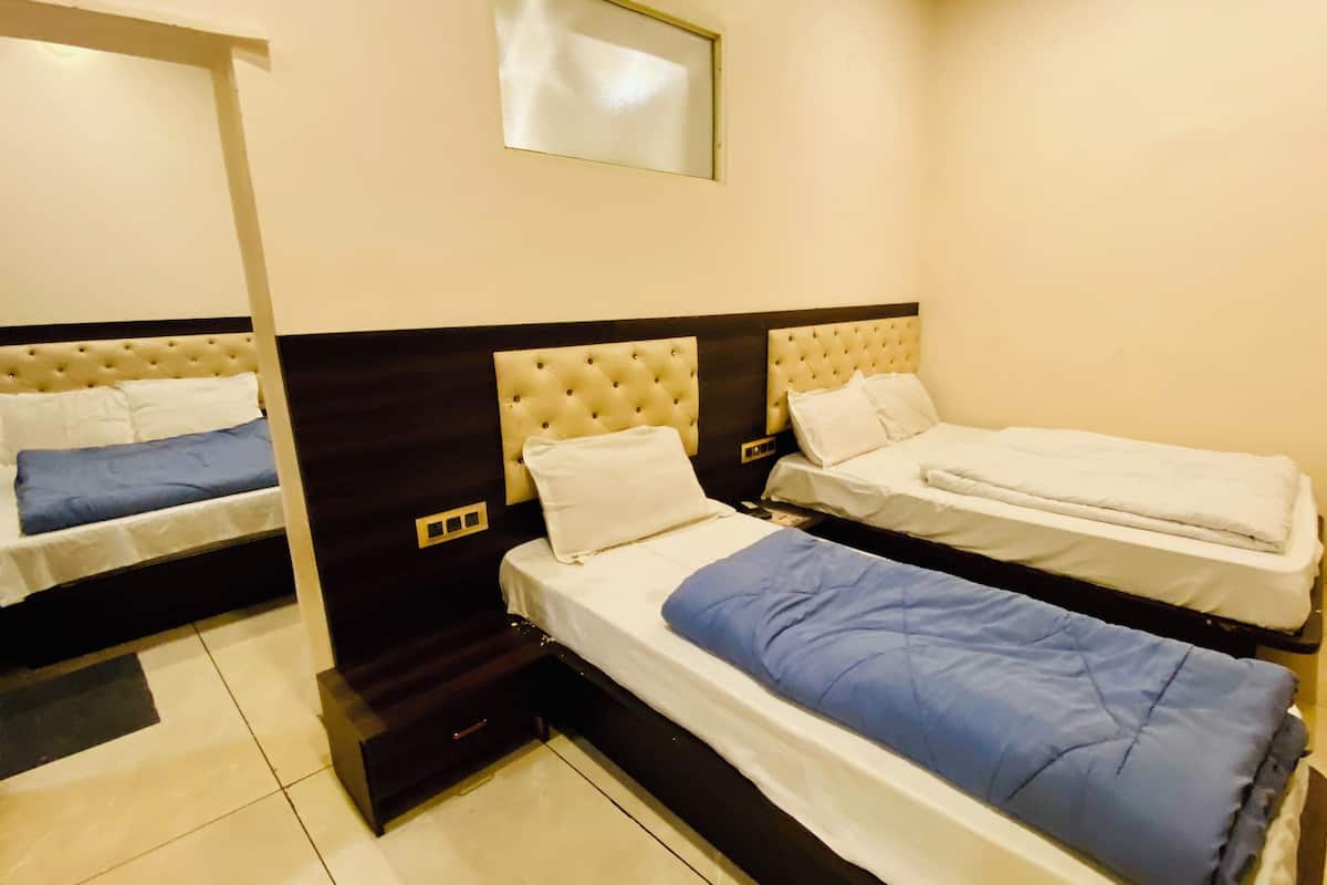 A hotel room with two single beds, a large mirror, and a small desk.