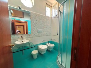 Een douche, een haardroger, een bidet, handdoeken
