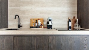 A kitchen with a modern design, featuring a wooden countertop, a black faucet, a coffee machine, and various kitchen items. - Elegant Coastal Retreat in Knokke-heist (Knokke-Heist)