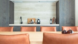 A modern kitchen with a built-in stove, a coffee machine, and a wine bottle on the counter. - Elegant Coastal Retreat in Knokke-heist (Knokke-Heist)