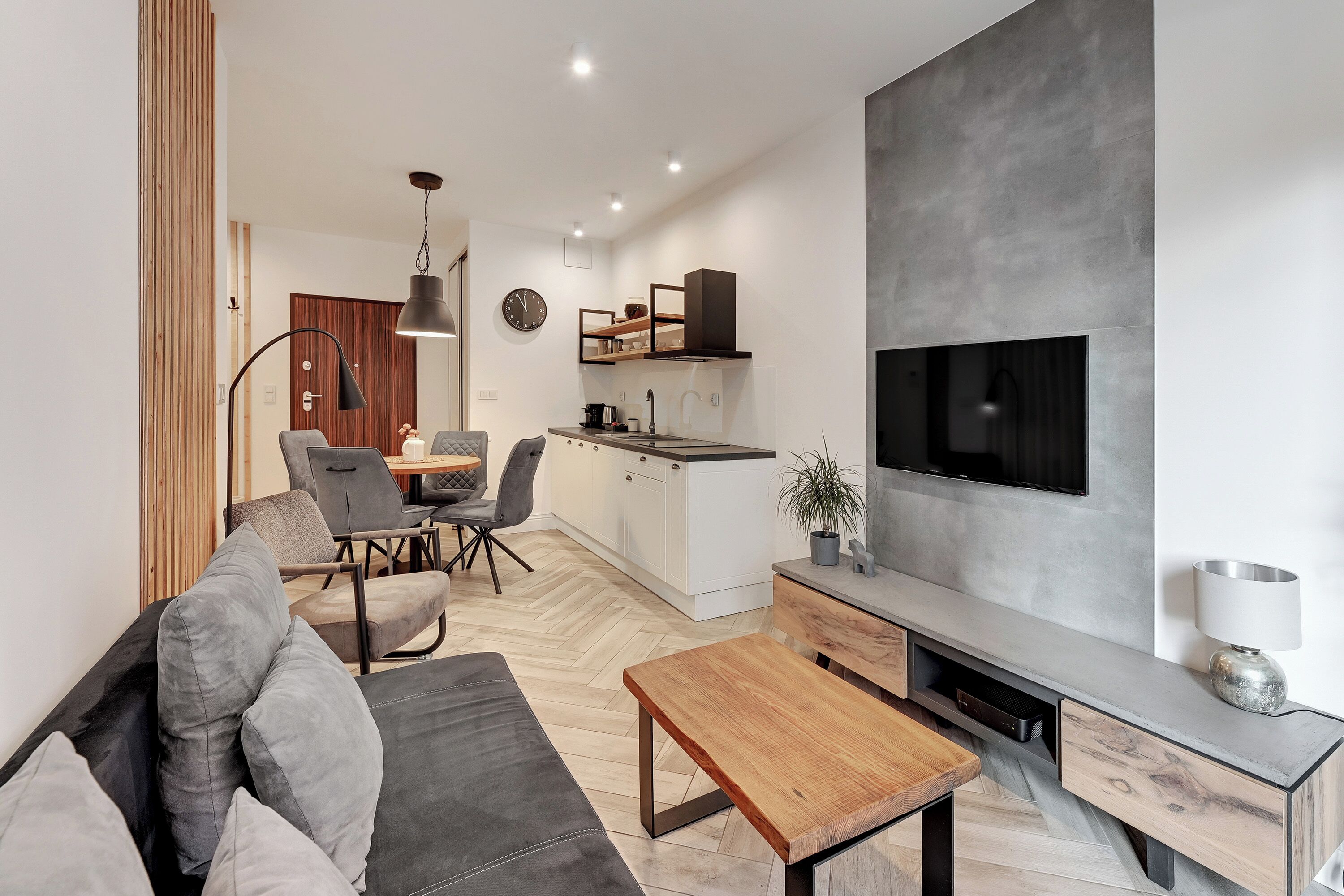 A modern living room with a sofa, coffee table, and dining area.