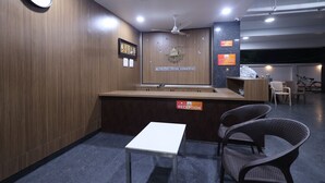A reception area with a reception desk, a clock, and a reception sign. - Tirupati Prime Homestay (Tirupati)