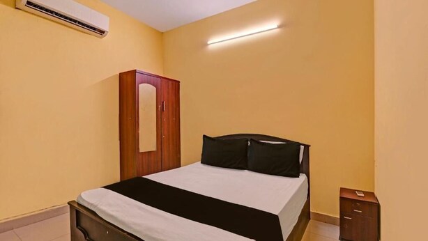 Un dormitorio con una cama, un armario y una mesita de noche.