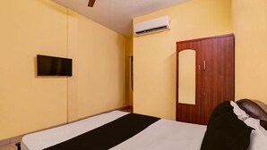 Una habitación con cama, armario, aire acondicionado y televisor.