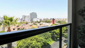 A cityscape view from a balcony with a palm tree and a potted plant. - w* | Cozy 1BR w/ Balcony in San Isidro (Lima)