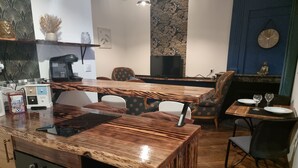 A modern kitchen with a wooden countertop, a built-in oven, and a dining area with a table and chairs. - prestigieuse résidence - parking (Bellac)