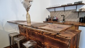 A modern kitchen with a wooden island, bar stools, and a decorative vase. - prestigieuse résidence - parking (Bellac)