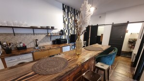 A modern kitchen with a wooden island, bar stools, and a decorative vase. - prestigieuse résidence - parking (Bellac)
