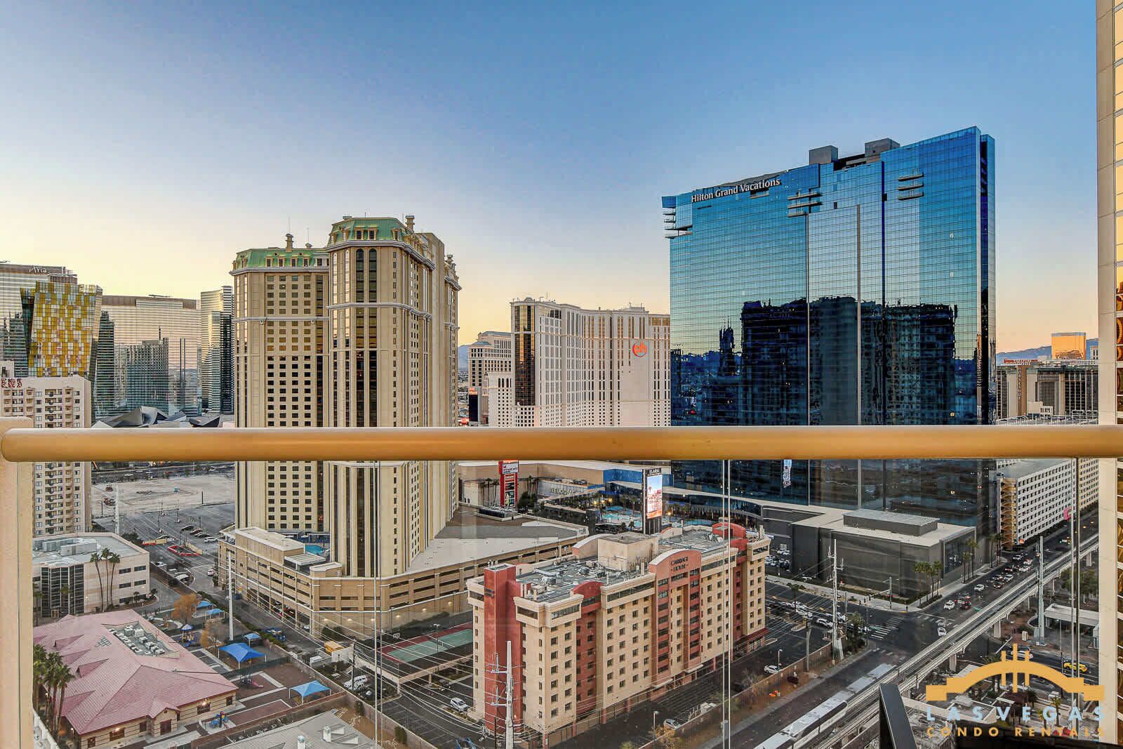 Stadsbeeld met hoge gebouwen, waaronder een Hilton Grand Vacations hotel, en uitzicht op Las Vegas vanaf een balkon.