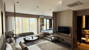 Una habitación de hotel moderna con una cama grande, un sofá, un comedor y un televisor.