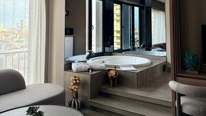 Un baño moderno con una bañera grande, un espejo y vistas a la ciudad.