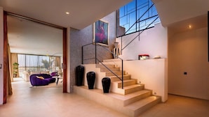 Ein modernes Interieur mit Treppe, einer Couch und einem Gemälde.