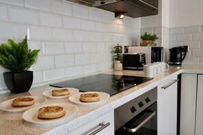 Enjoy cooking in this well-equipped kitchen with a range hood, oven, and modern appliances.