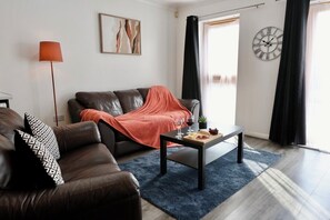 Relax in this stylish living room with a comfortable sofa, coffee table, and floor lamp.