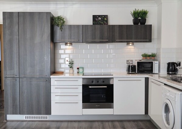 Enjoy cooking in this well-equipped kitchen with oven, microwave, and dishwasher.