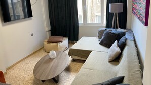 A modern living room with a sofa, ottoman, and coffee table. - Praxitelous Apartments by Athens Urban Retreat (Athens)