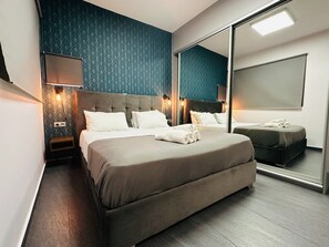 Een moderne hotelkamer met een groot bed, een nachtkastje, een spiegel en een wandlamp.
