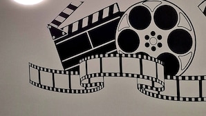 Un mur décoré avec un motif représentant une bobine de film et une claquette de cinéma.