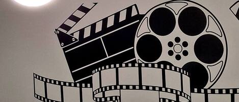 Un mur décoré avec un motif représentant une bobine de film et une claquette de cinéma.