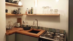 Eine Küche mit Gasherd, Spüle und hängenden Lampen.