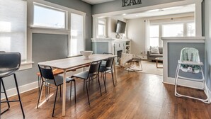 Una cocina moderna con comedor, una trona para bebé y una chimenea.