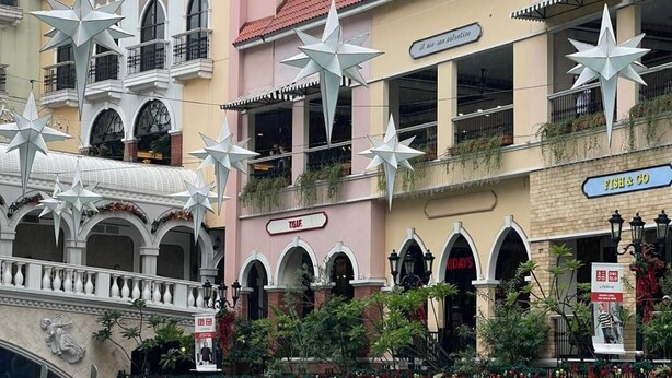 Un canal con un puente, barcos y edificios decorados con estrellas.