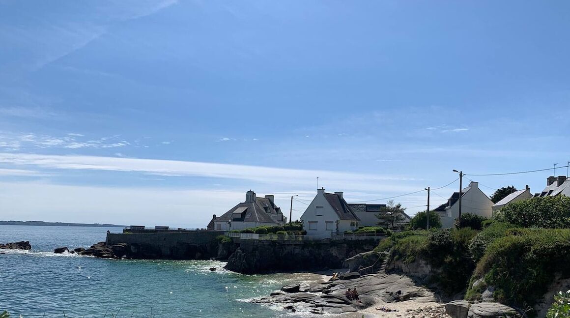 Una propiedad costera con casas en un acantilado con vistas al mar.