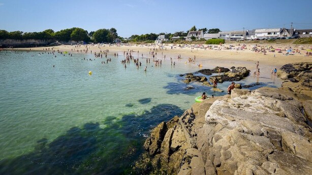 A beach with clear water, rocky shore, and buildings in the background. - Beautiful villa in Lomener-beach, restaurants, and shops within walking distance (Ploemeur)