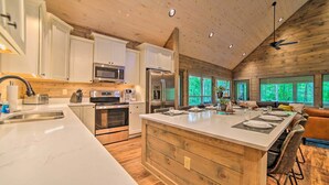 Una cocina moderna con armarios blancos, electrodomésticos de acero inoxidable y una isla grande.