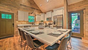 Una cocina moderna con armarios blancos, electrodomésticos de acero inoxidable y una isla grande con asientos.