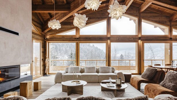 Un salón espacioso con chimenea, ventanas amplias y una zona de estar acogedora.