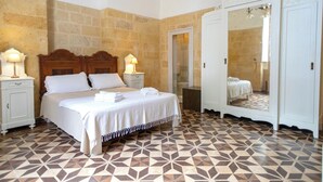 A hotel room with a large bed, a wardrobe, and a bathroom visible through an open door. - Villa La Tonnara (Porto Cesareo)