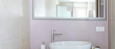 A bathroom with a white sink, a mirror, and a towel rack.