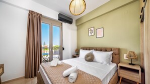 A hotel room with a large bed, a nightstand, a lamp, and a view of the outdoors through a sliding door.