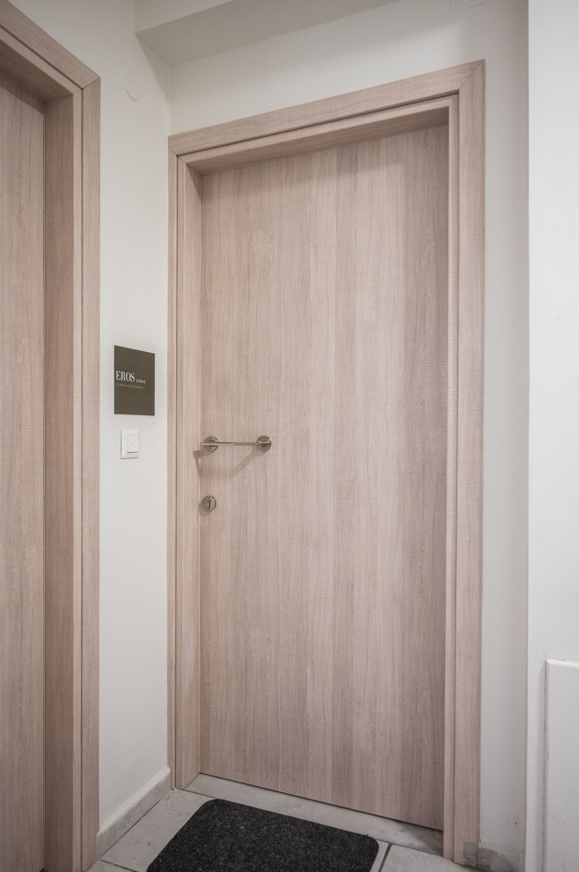 Una puerta de madera con un picaporte y una pequeña placa encima.