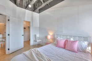 A modern bedroom with a large bed, a desk, and a chair. - This condominium is a 1 bedroom(s), 1 bathrooms, located in Nashville, TN. (Nashville)
