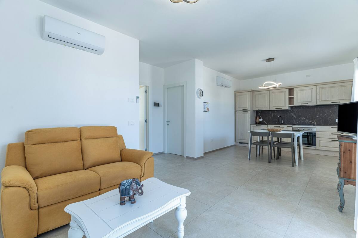 Un salon moderne comprenant un canapé, une table basse et un coin repas avec des chaises et une table.