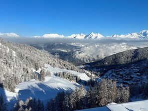 Un paisaje montañoso cubierto de nieve con un pueblo en el valle.