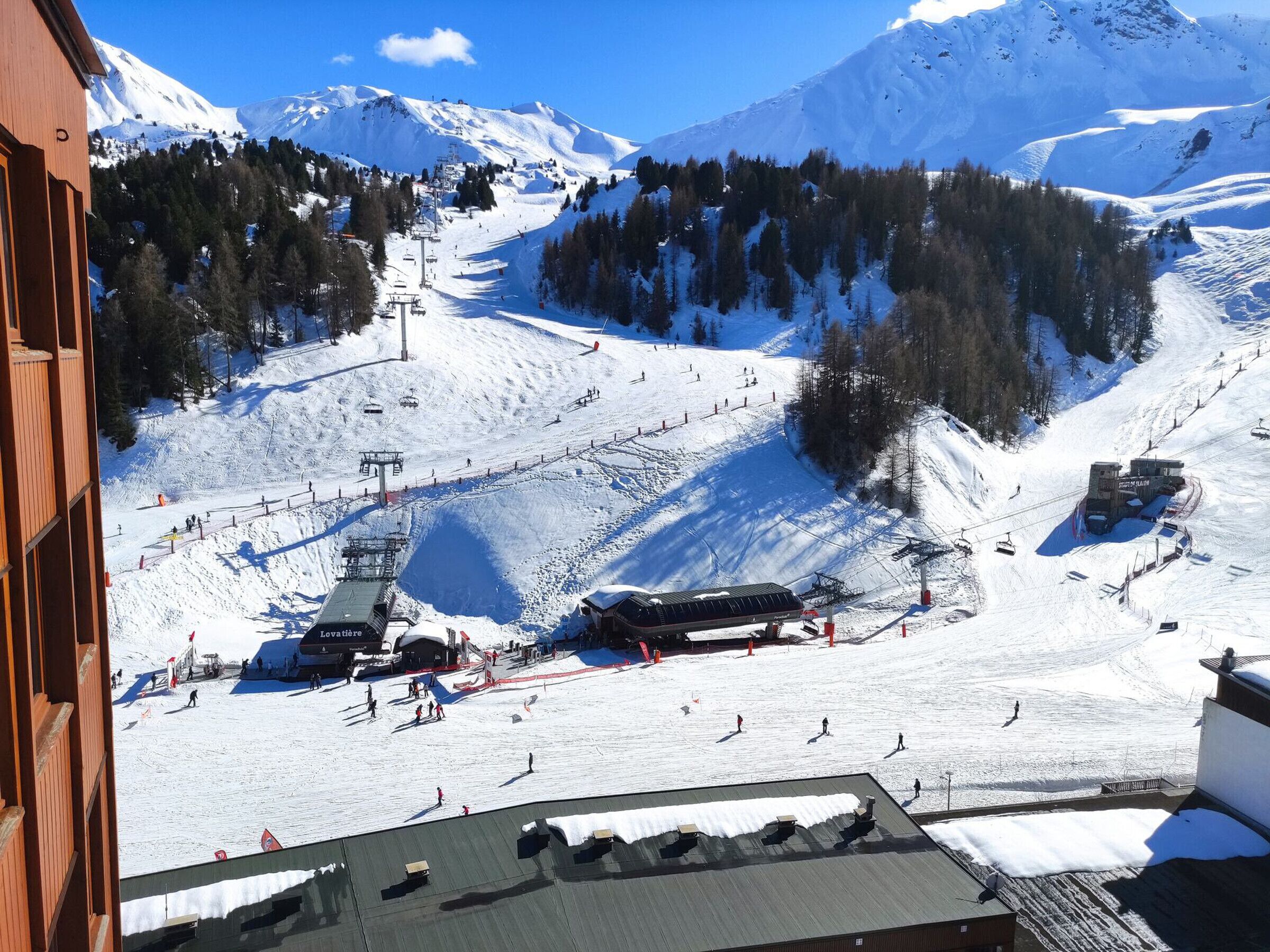 A ski resort with a chairlift, ski slopes, and a mountain backdrop.
