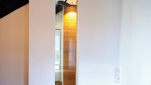 A hallway with a wooden wall and a white door. - Luxury Suite Sunrise in Losone (Losone)