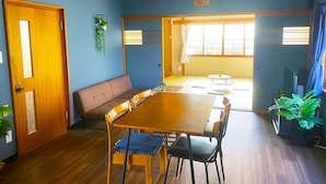 Un comedor con una mesa y sillas de madera, un sofá y un televisor.