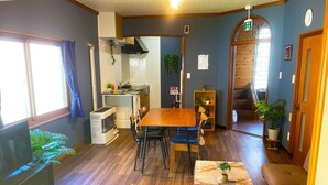 Un espacio habitable compacto con comedor, kitchenette y una pequeña zona de estar.