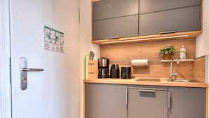 Une cuisine moderne équipée d’un four encastré, d’une machine à café et d’un évier.