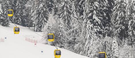 A snowy ski slope with yellow ski lifts and red and blue flags marking the course.