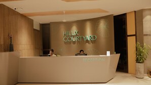 A reception desk with the sign "Hilux Courtyard" and a "Reception" label. - Hilux Courtyard (Palakkad)