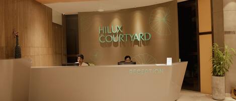 A reception desk with the sign "Hilux Courtyard" and a "Reception" label.