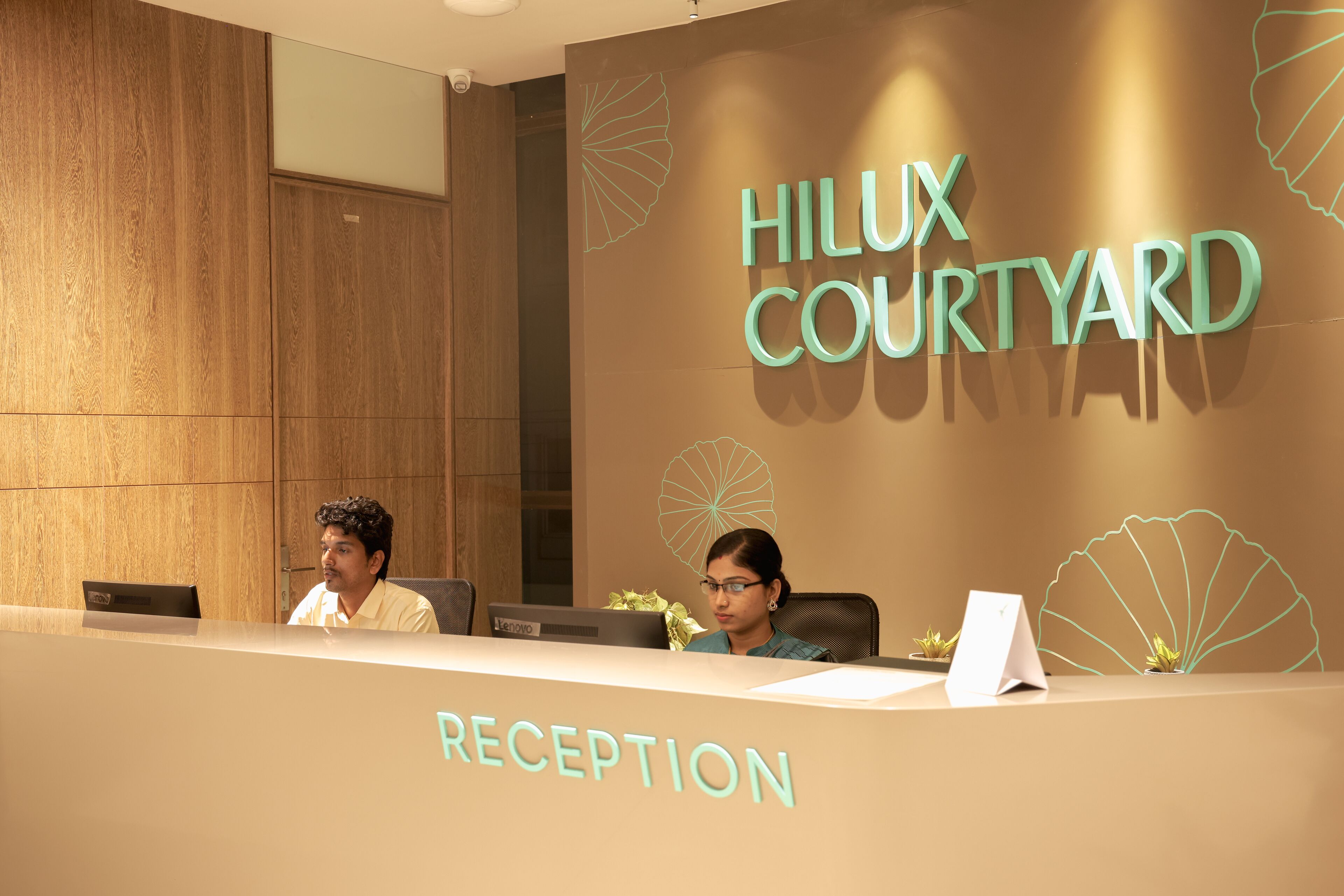Un mostrador de recepción con un letrero que dice "HILUX COURTYARD" y una etiqueta que indica "RECEPción".