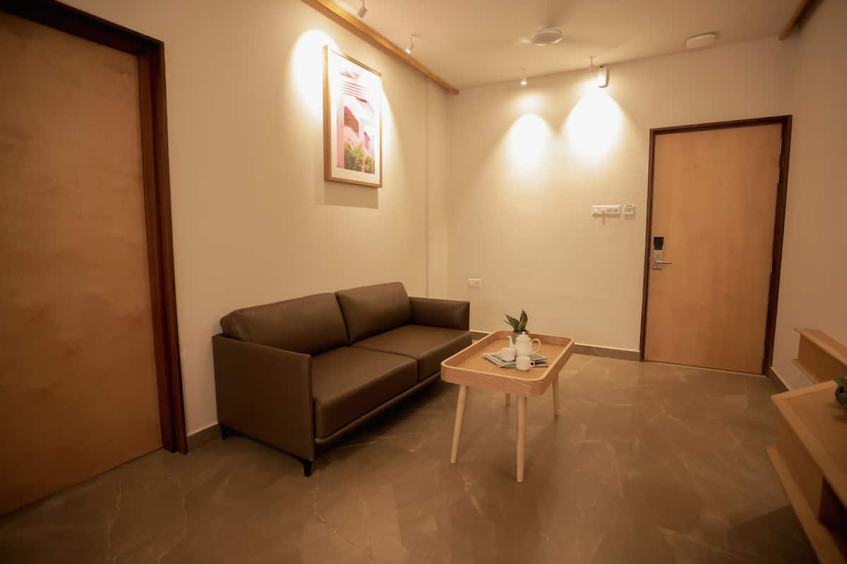 A modern living room with a brown sofa, a wooden coffee table with a plant, and a door with a handle.