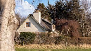A house with a sloped roof, a chimney, and a window.