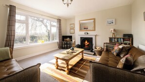A cozy living room with a fireplace, a sofa, a coffee table, and a television.